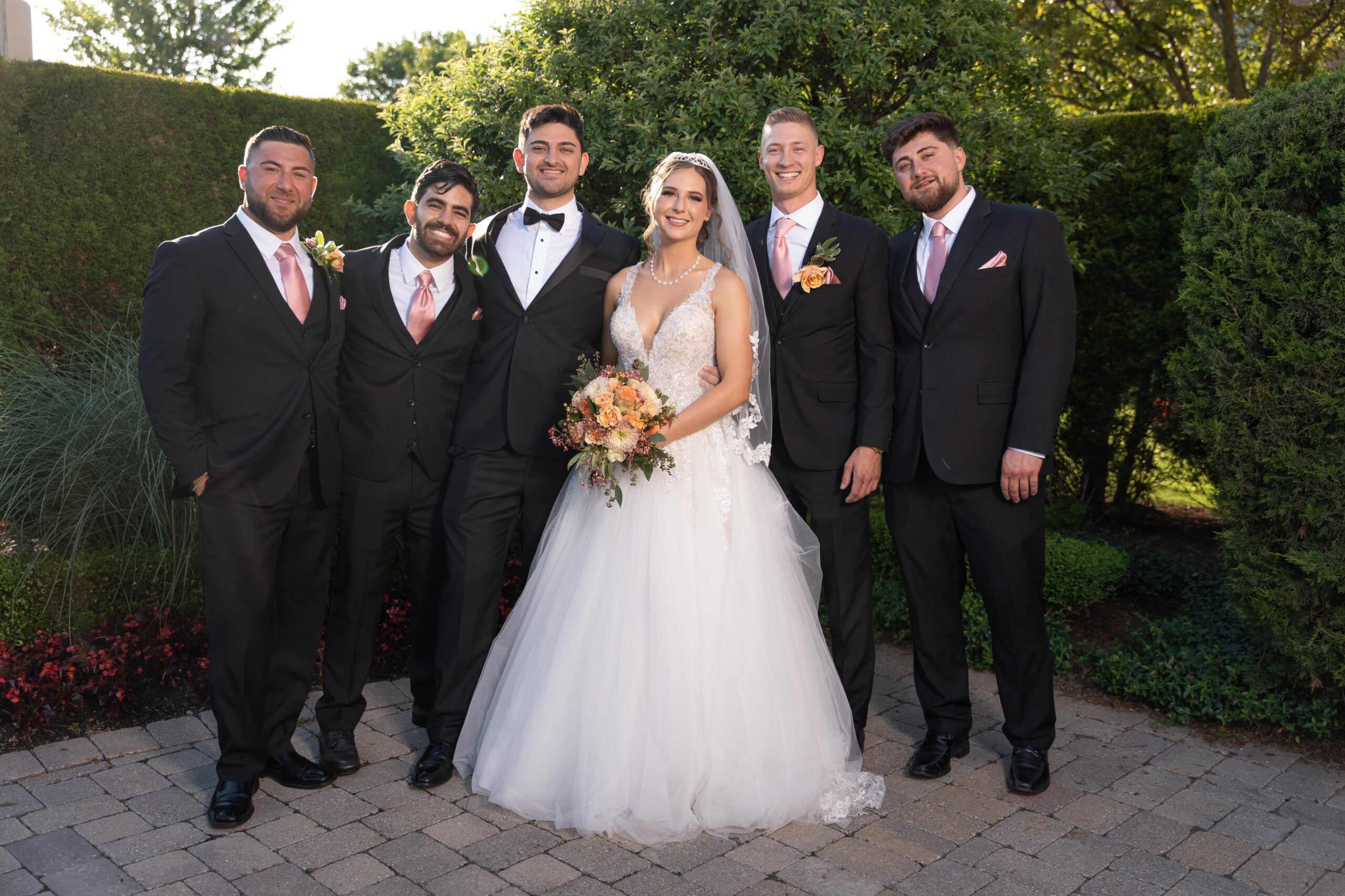 Wedding party in black suits with bride and groom in black tux